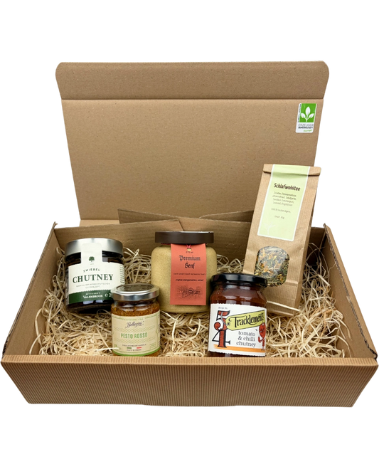 Geschenkpaket mit Valenbrook Zwiebel Chutney, Tracklements Tomato & Chilli Chutney, Bellizini Pesto Rosso, Senfmühle Kleinhettstedt Premiumsenf und Thüringer Tee- und Kräutermanufaktur Schlafwohltee in einer Geschenkverpackung.