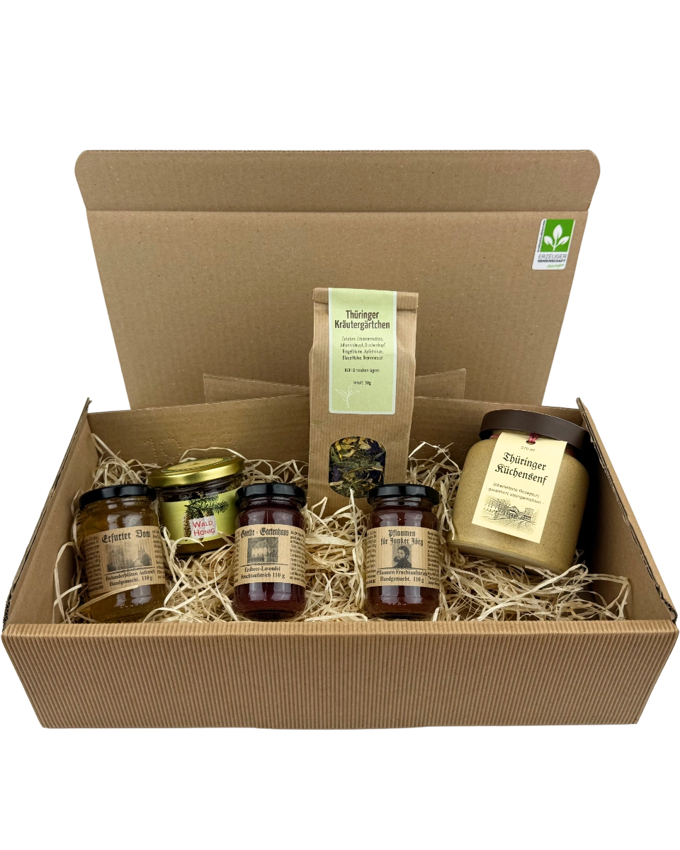Thüringer Genussreise Geschenkpaket mit regionalen Spezialitäten wie Fruchtaufstrichen, Waldhonig, Küchensenf und Kräutertee im Präsentkarton mit Holzwolle