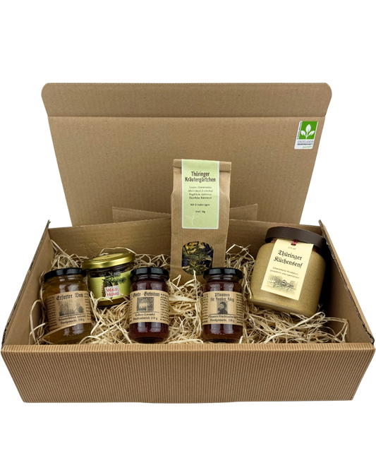 Thüringer Genussreise Geschenkpaket mit regionalen Spezialitäten wie Fruchtaufstrichen, Waldhonig, Küchensenf und Kräutertee im Präsentkarton mit Holzwolle
